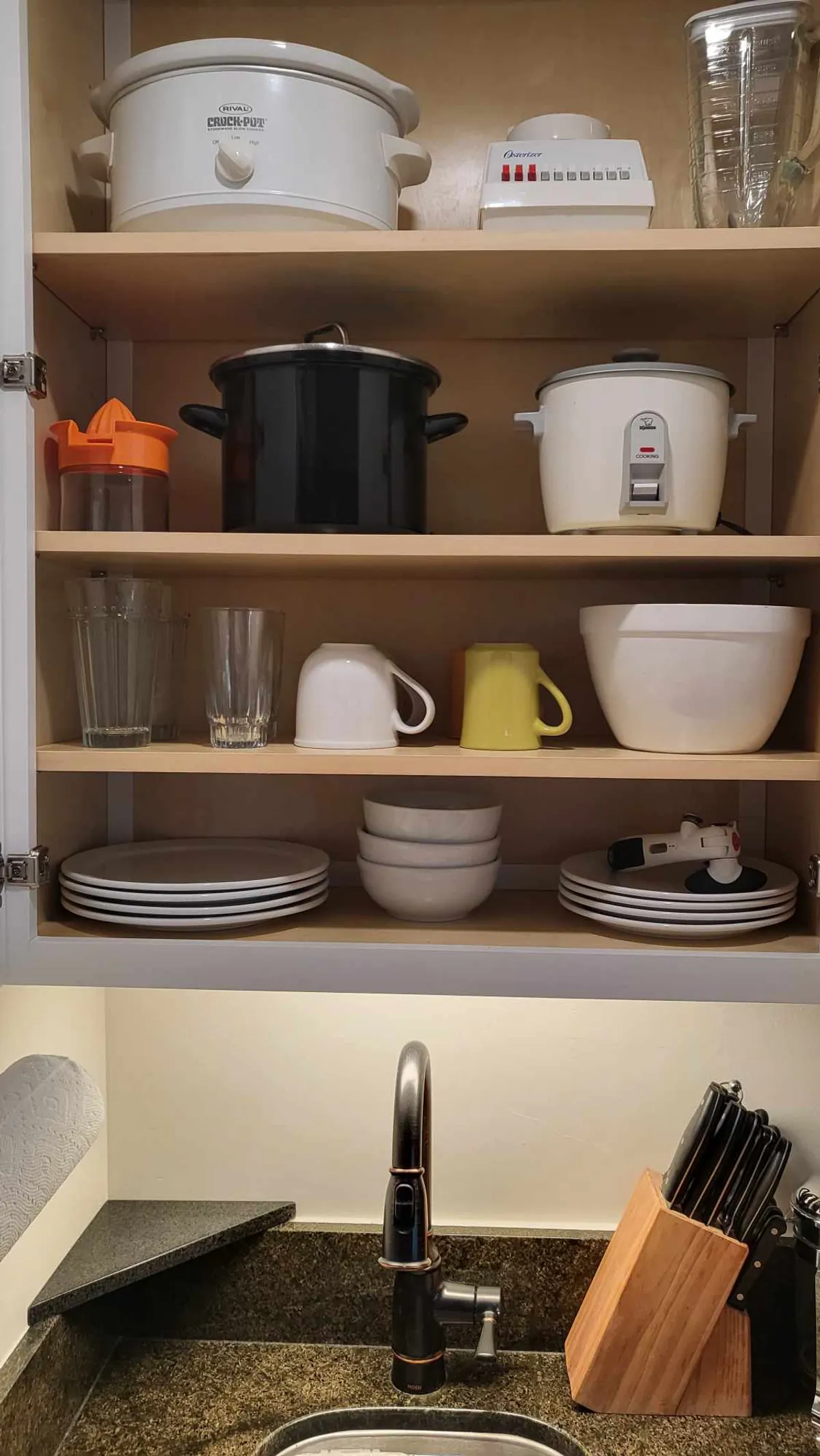 A practical kitchen area filled with essential appliances, glassware, and neatly arranged ceramics. The setup is designed for effortless cooking and dining, inviting residents to enjoy both everyday routines and special meals in their studio home.